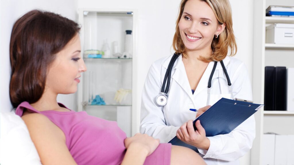 A doctor consults a pregnant patient in gynecologic service in illinois urgent care, reflecting the personalized and attentive healthcare provided in Illinois.