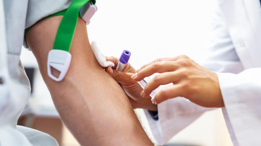 The image captures a patient's arm being prepared for a blood draw by a medical professional, exemplifying the walk in lab services in Chicago urgent care clinic.